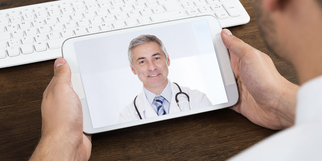 Tablet mit Arzt im Videogespräch – Symbolbild für die MD Medicus 24/7 Videoberatung