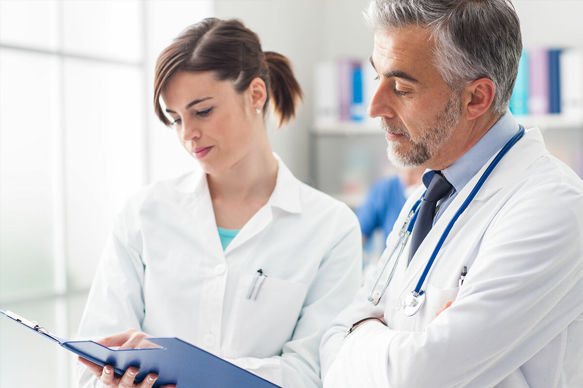 Two medical professionals review documents – symbolic image for MD Medicus medical assistance for B2B clients